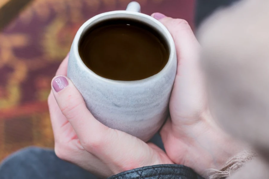 Two hands wrapped around a warm mug of Essential™
